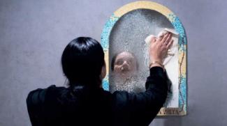 Spectacle nommé "PINK !" joué à l'espace des Augustins Femme aux cheveux noirs de dos nettoyant un miroir avec un papier