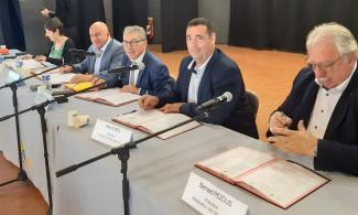 Signature charte energeie des élus qui signe un document avec le président michel weill